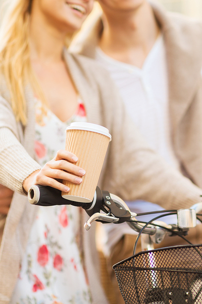 summer holidays, bikes, love, relationship and dating concept - closeup of couple holding coffee and