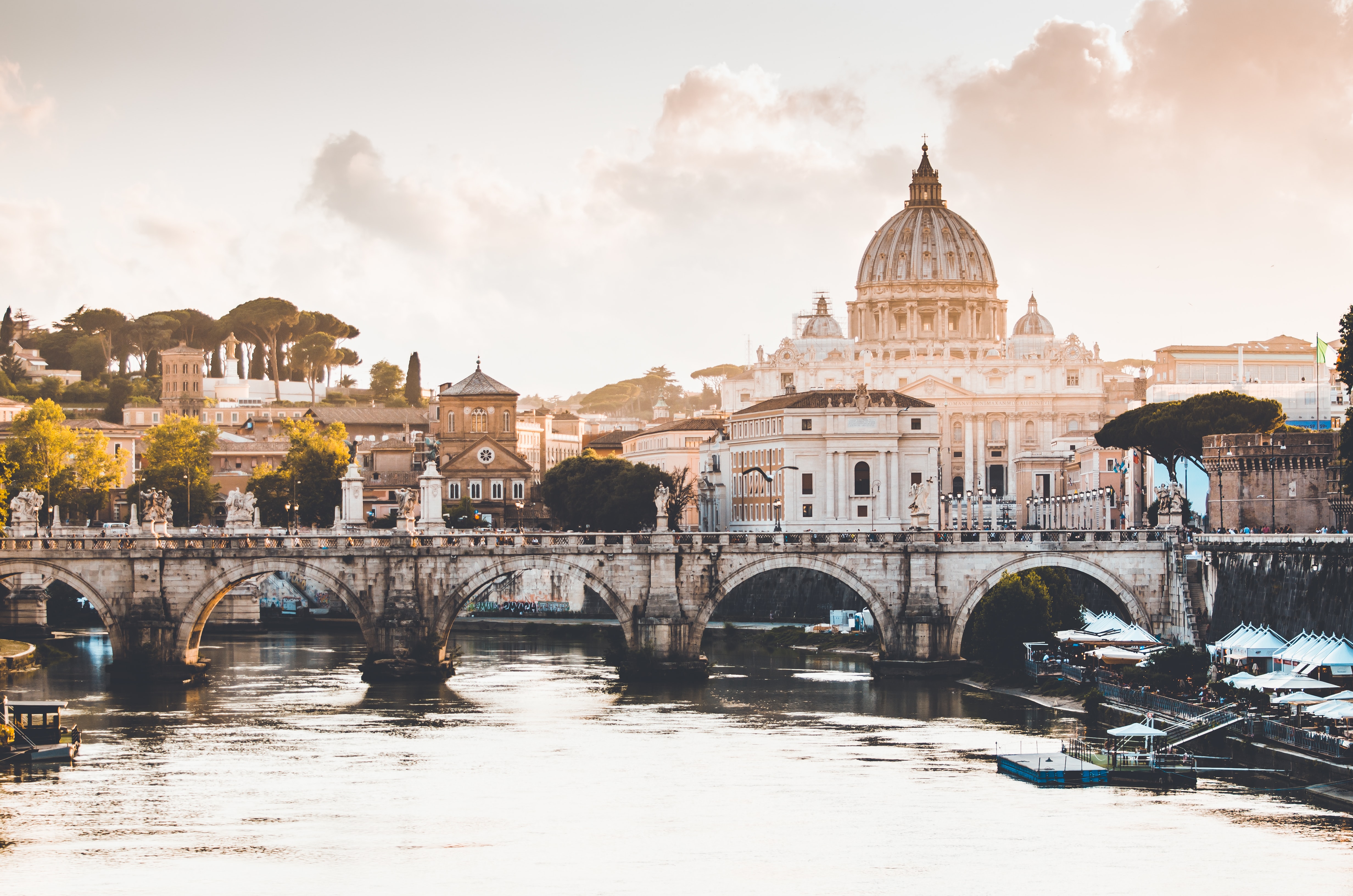 A photo of the Vatican at sunrise showing a bridge over a waterway.